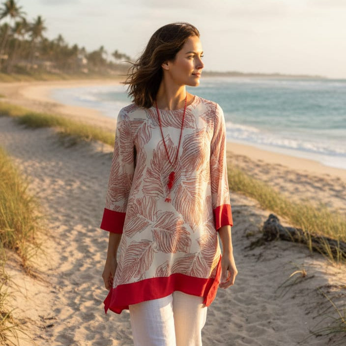 Woman walking on a beach wearing a red and white outfit.